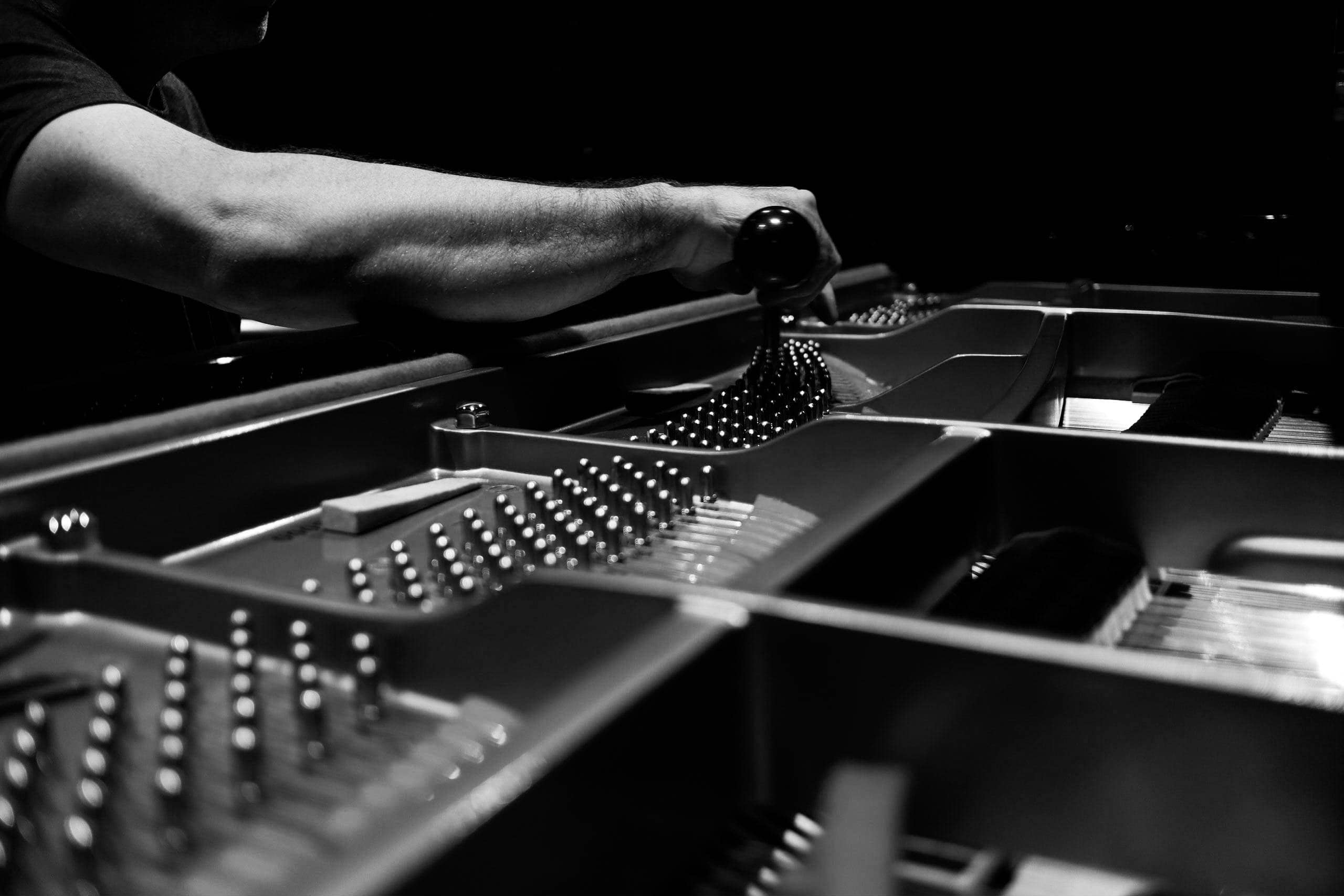 Piano technician tuning a piano